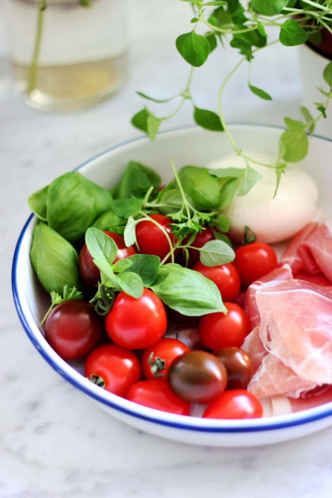 cherry tomatoes , peeled whole onion, and a piece of fresh salmon.