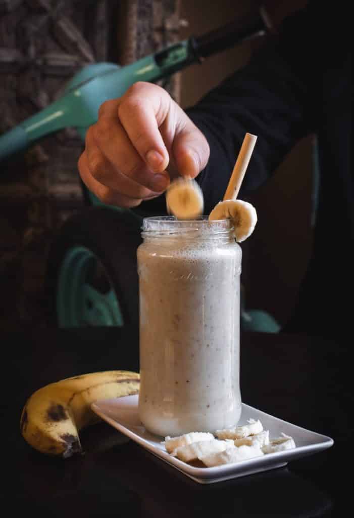 A Detox Smoothie with a straw and bananas on top