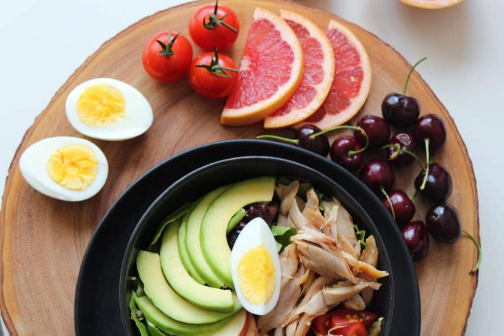 Variety of Food on Wooden Coaster with fruits and vegetables.