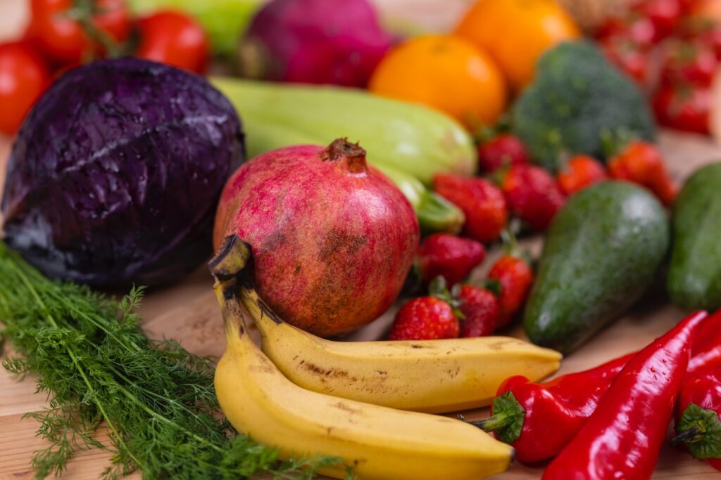 Healthy food choices of bananas, strawberries, avocados, red chili peppers and pomegranates.