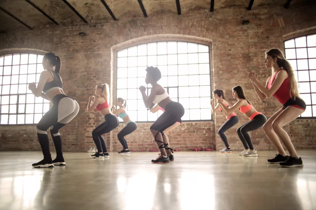 Six woman in a exercise class doing plank exercises.