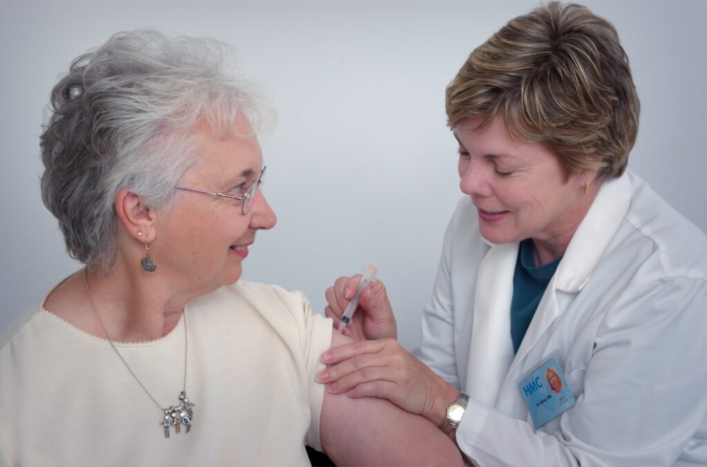 Female doctor giving a female patience an injection.