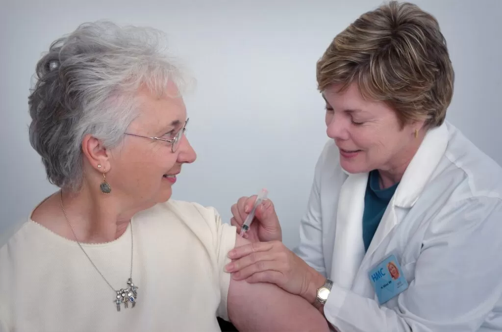 Female doctor giving a female patience an injection.