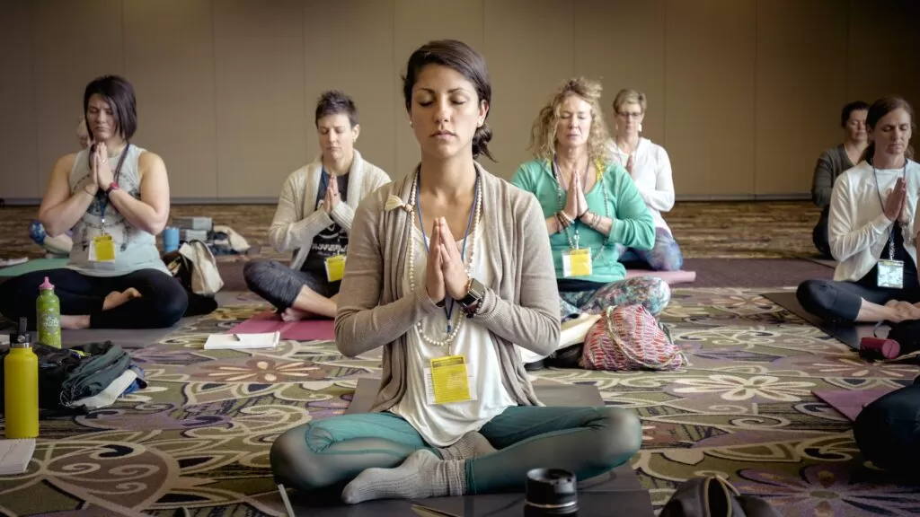 A group of men and women meditating together.