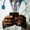 A man with a stethoscope around his neck using the Apple Health app.