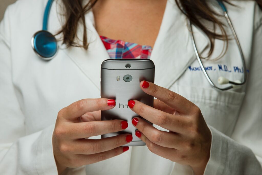 A female doctor holding her iPhone with the Apple Health app reading it.