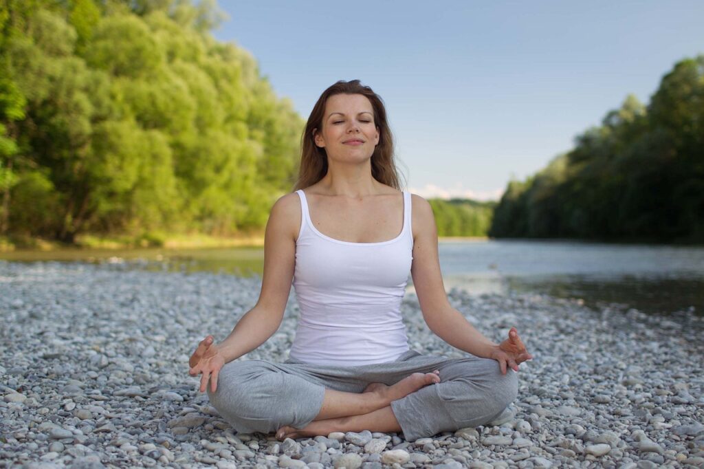 woman in a crossed leg palms on knees yoga position meditating