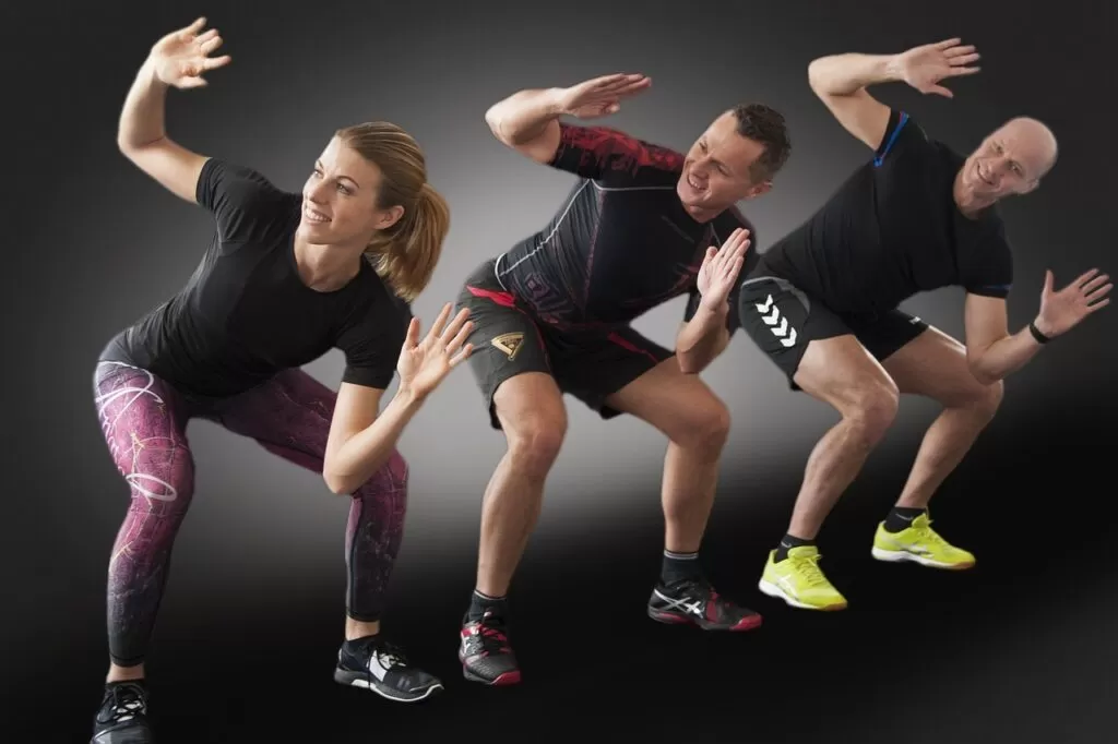 Three people a woman and two men squatting doing a CrossFit exercise. kettlebell, fitness, crossfit-3293481.jpg