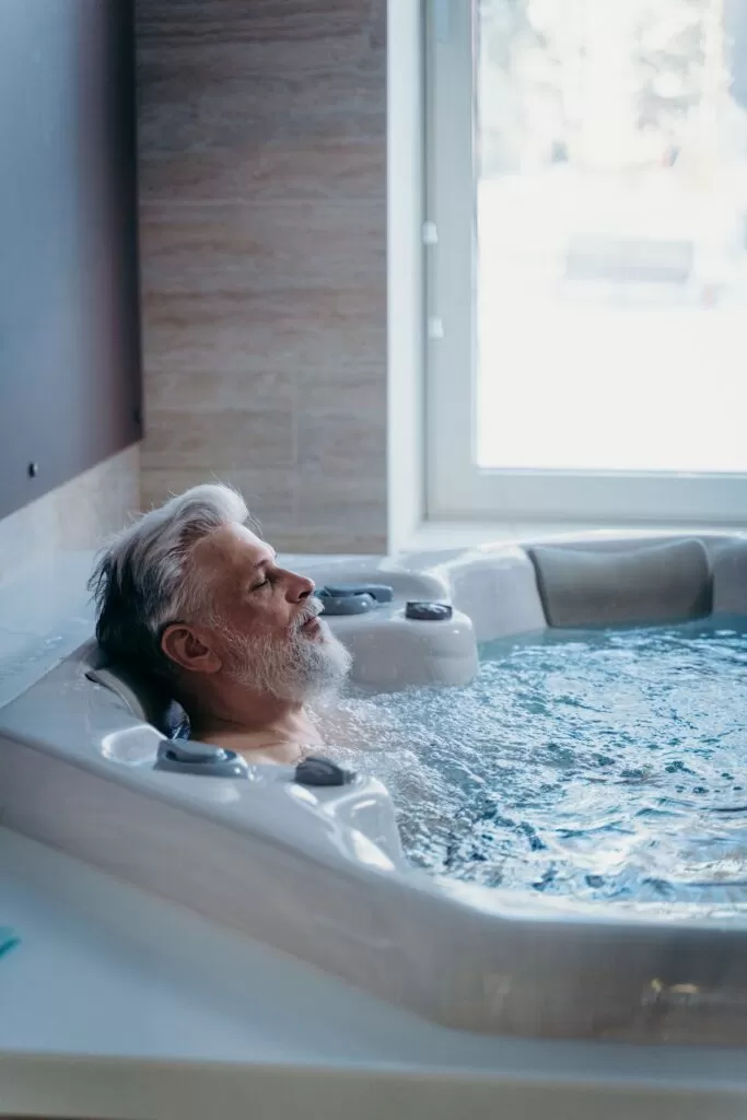A bearded man relaxing in a hot tub.