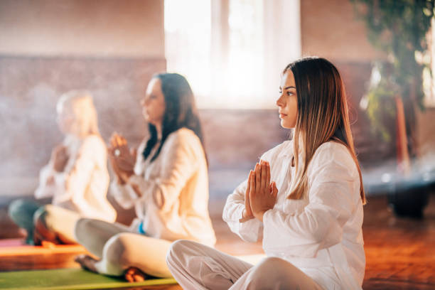 Group of people meditating visualising during yoga session