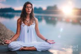 Woman meditating by a lake