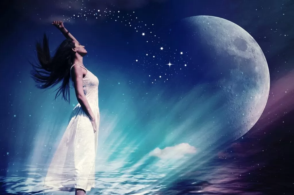 A woman manifesting and using the Law of Attraction staring at the moon.