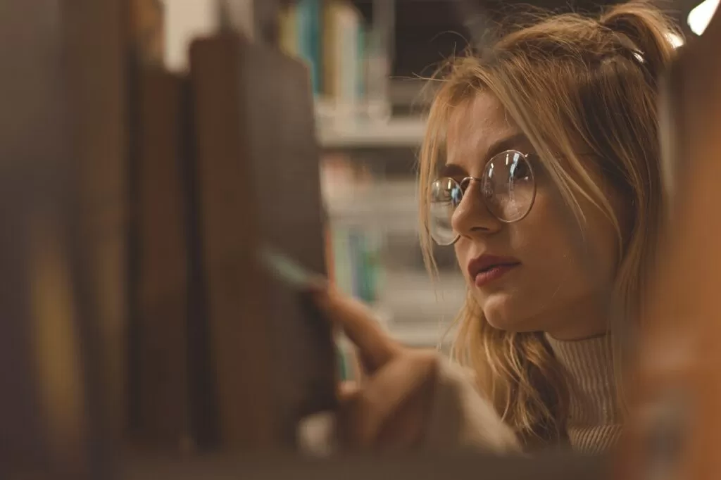 A woman choosing what health and wellness book to read.