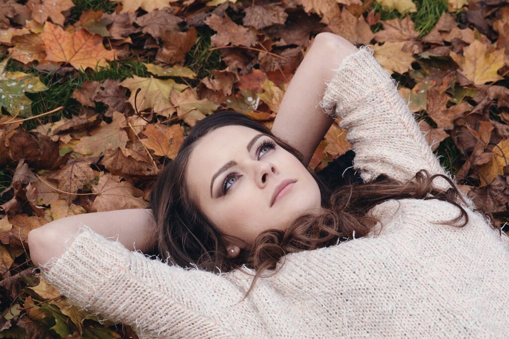 A woman who a brunette lying down outside.