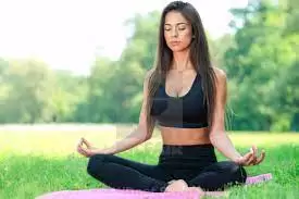 Woman sitting in a yoga position meditating.