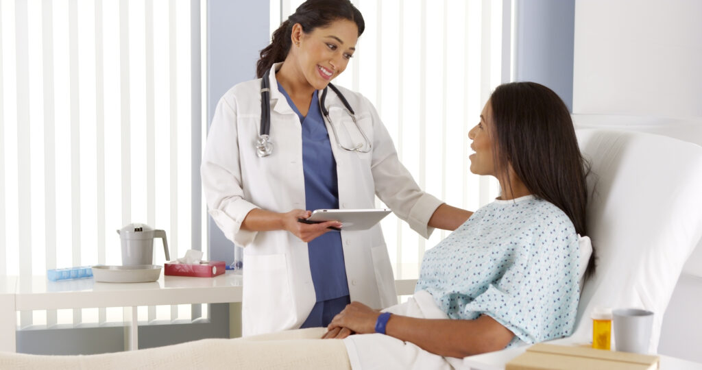 Hispanic female doctor talking to African American patient.