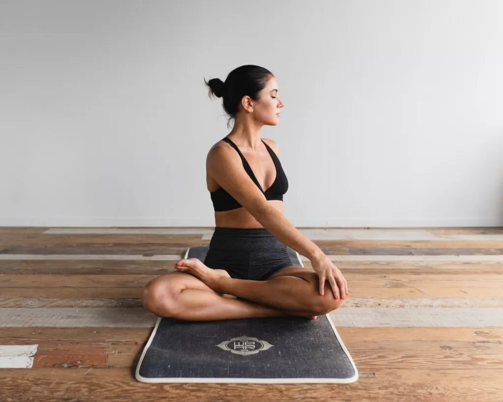 A woman in a yoga pose on a yoga mat.