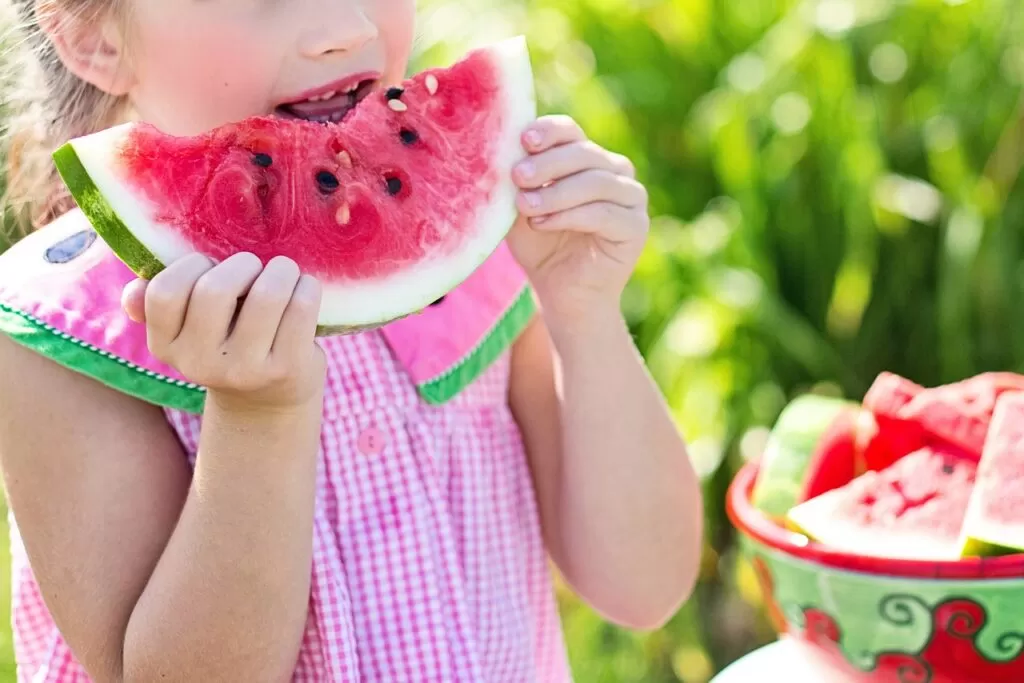 Little girl eating watermelon.