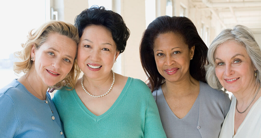 Four happy smiling breast cancer surviving women.