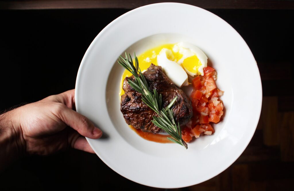 Steak with poached eggs and tomatoes.