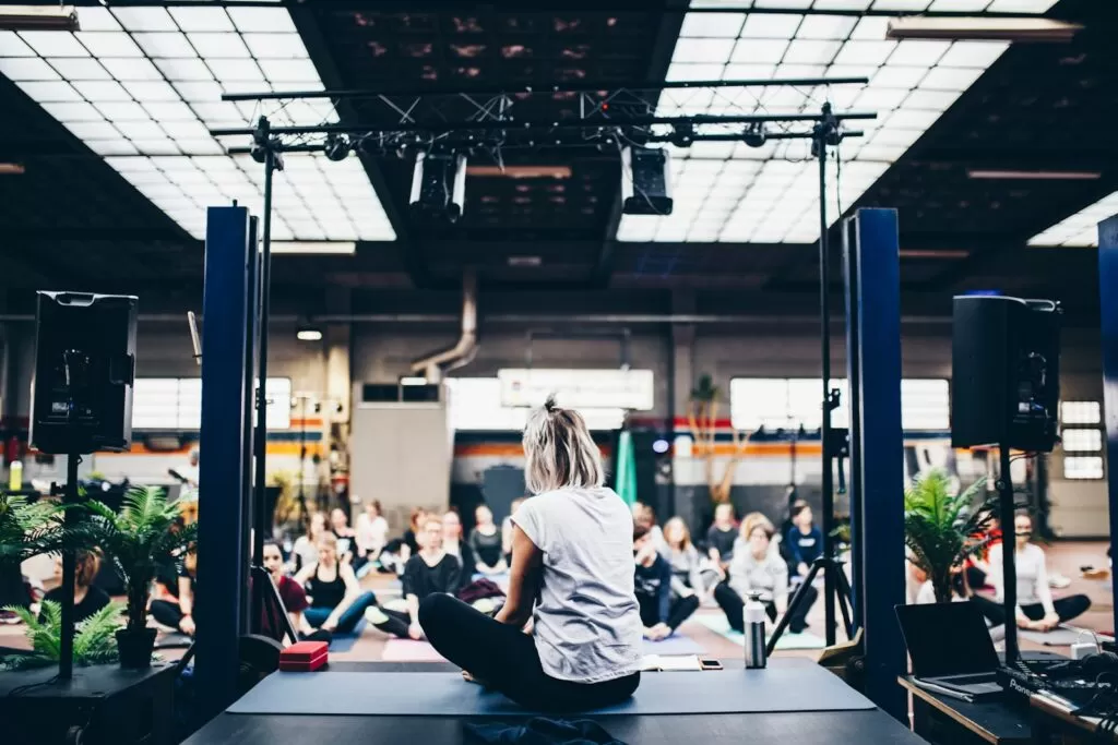 woman sitting in the yoga mat in front of a yoga class