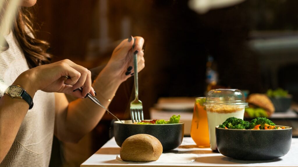 person holding silver fork and knife and eating dinner