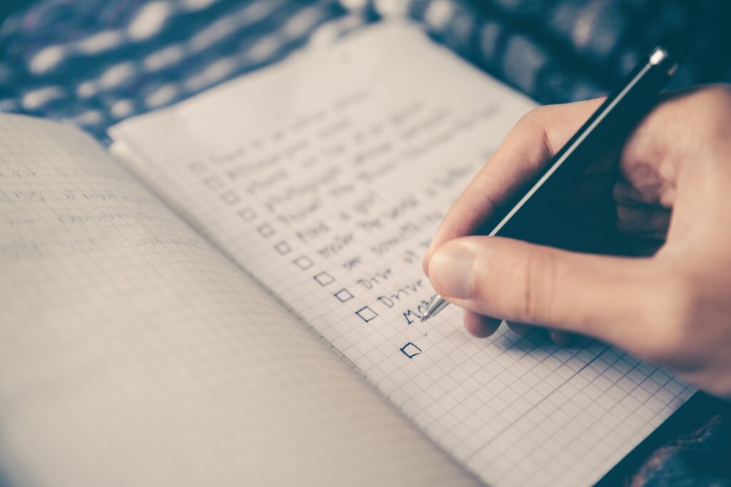 person making a diet planning list in a book