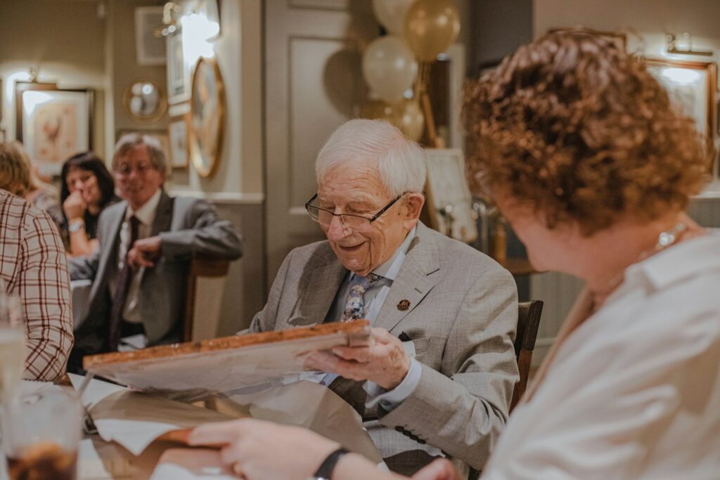 smiling man holding box at the table