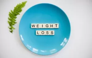 blue and white i love you round plate with the weight loss spelled out in block letters