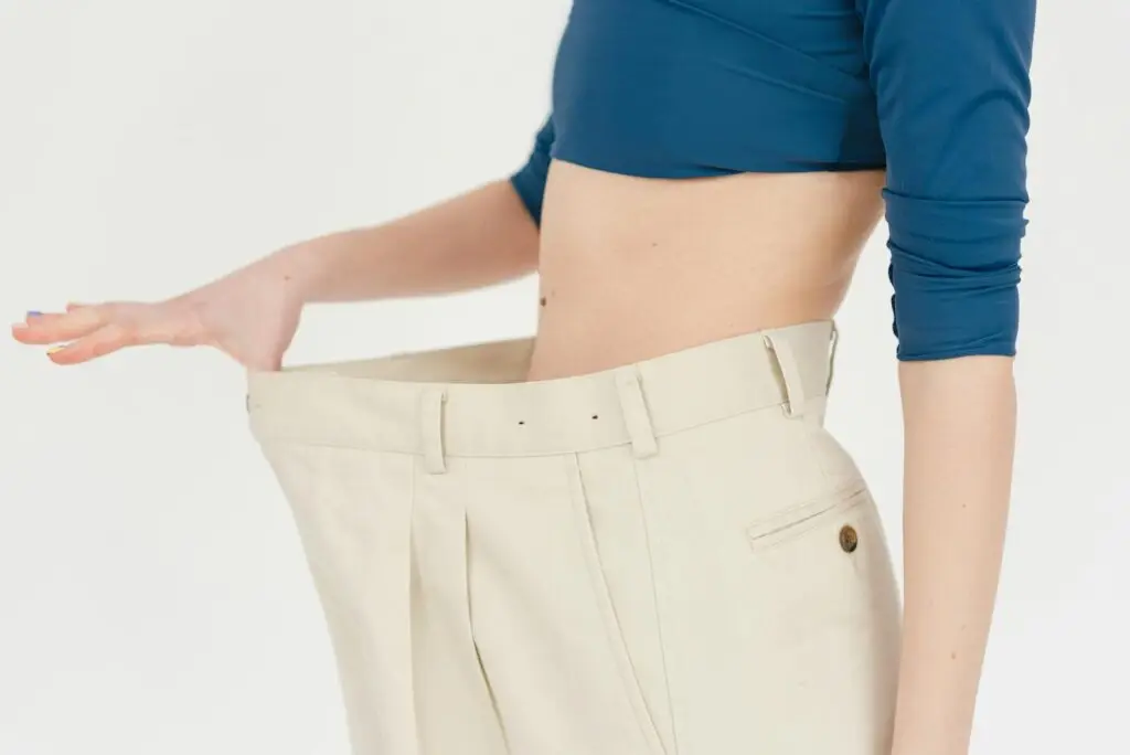 woman in oversized pants after losing weight on top ten diet plans